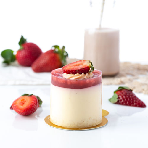 Strawberry cheesecake small on white with fresh strawberries and milk